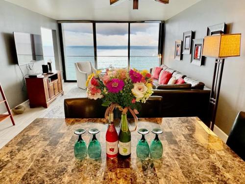 Ocean View Luxury Condo Oceanfront and Pool في سان دييغو: غرفة عليها طاولة عليها اربع زجاجات