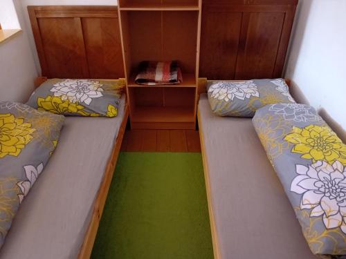 two beds in a small room with a closet at Statek in Veverská Bítýška