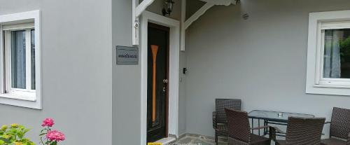 a front door of a house with a table and chairs at Mountainside in Vounoplagiá