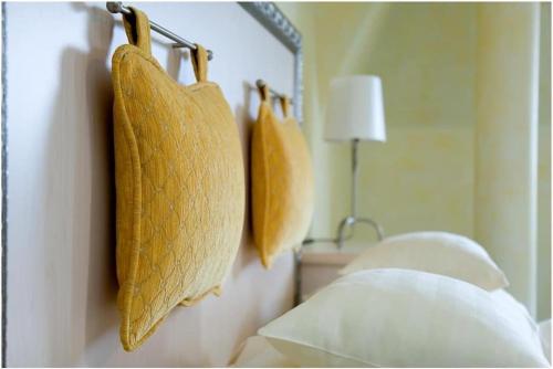 a bedroom with yellow pillows hanging on a wall at Hétkúti Wellness Hotel in Mór