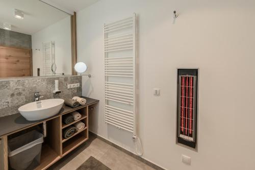 W łazience znajduje się umywalka i lustro. w obiekcie Winzerhäuser J&A Skringer w mieście Leutschach
