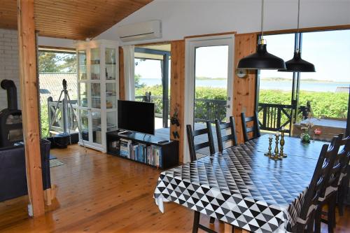 a dining room with a table and a television at Holiday home with panoramic ocean view near Kerteminde in Martofte