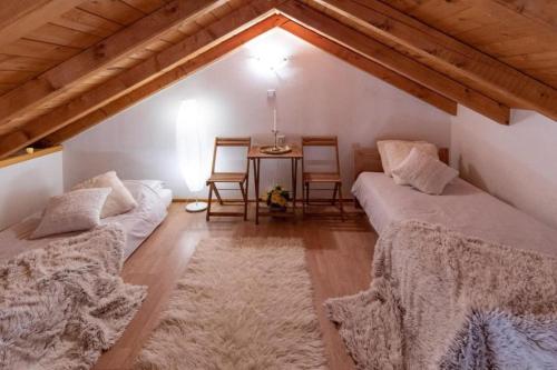 a attic room with two beds and a table at Villa Menalo in Neum