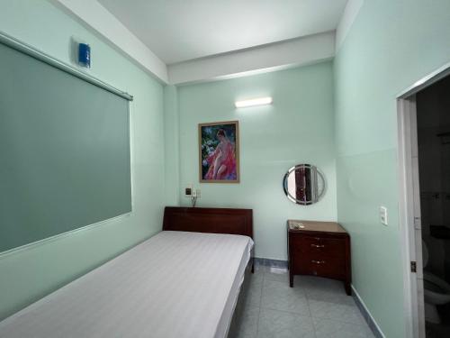 - une chambre avec un lit blanc et un miroir dans l'établissement Nhà nghỉ 2552, đường D4 , KDC Võ Thị Sáu , phường Thống Nhất , thành phố Biên Hòa, à Biên Hòa