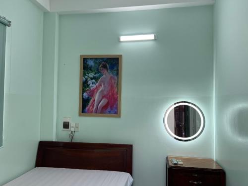 a white bedroom with a bed and a mirror at Nhà nghỉ 2552, đường D4 , KDC Võ Thị Sáu , phường Thống Nhất , thành phố Biên Hòa in Bien Hoa