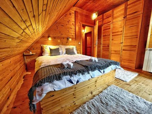 a bedroom with a bed in a wooden cabin at Kuća za odmor Snowdrop in Begovo Razdolje