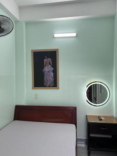a bedroom with a bed and a mirror on the wall at Nhà nghỉ 2552, đường D4 , KDC Võ Thị Sáu , phường Thống Nhất , thành phố Biên Hòa in Bien Hoa