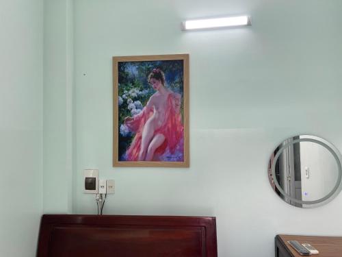 a painting of a woman on a wall with a mirror at Nhà nghỉ 2552, đường D4 , KDC Võ Thị Sáu , phường Thống Nhất , thành phố Biên Hòa in Bien Hoa