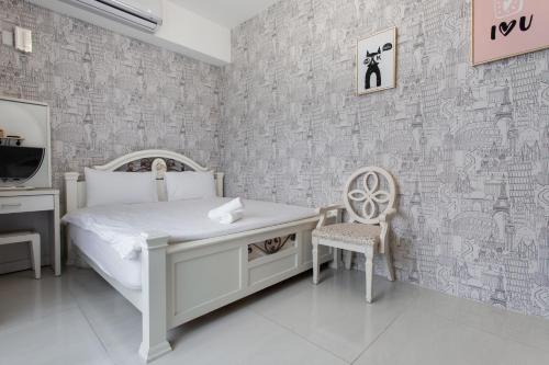 a bedroom with a bed and a desk and a chair at Travel Mind in Hualien City