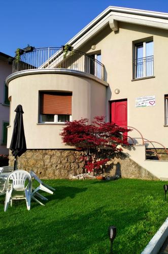 a house with an umbrella and a lawn at Villa Harriet in Sovere