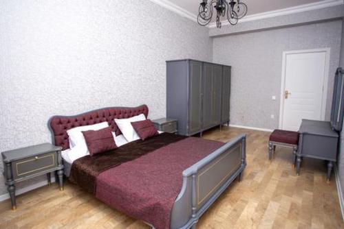 a bedroom with a large bed with a red bedspread at VIP апартамент in Sumqayıt
