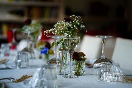 una mesa con varios jarrones con flores en ellos en Settecentoalberi Agriturismo en Noventa di Piave