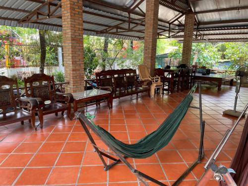 a hammock in a restaurant with tables and chairs at Đông's Garden Home in Can Tho