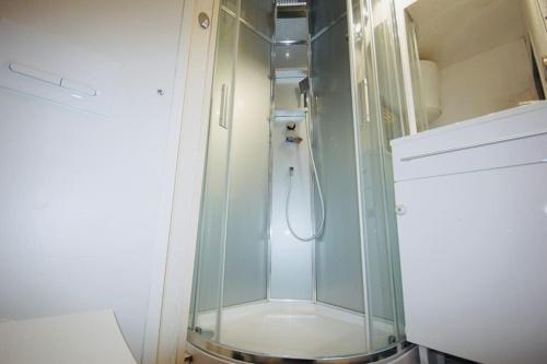 La salle de bains est pourvue d'une douche et d'une cabine de verre. dans l'établissement Appartement rez de jardin à 150m de la plage, à Leucate