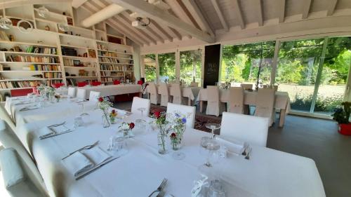 a dining room with white tables and white chairs at Settecentoalberi Agriturismo in Noventa di Piave