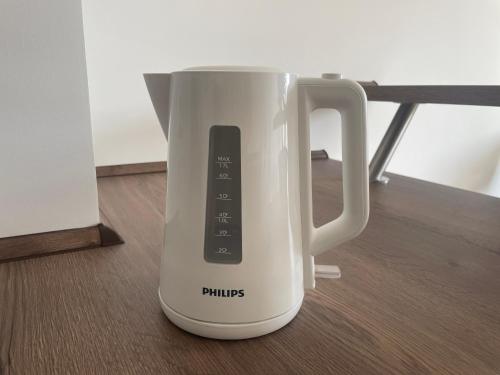 a white mug with a remote control in it at Neue stilvolle 2-Zimmer Wohnung im Zentrum von Wolfsburg in Wolfsburg