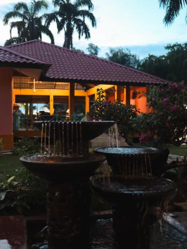 a building with a fountain in front of it at papaya resort in Kampung Tekek