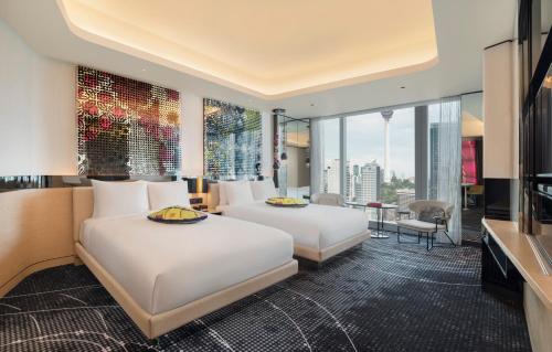 クアラルンプールにあるW Kuala Lumpur Hotelのベッド2台とテレビが備わるホテルルームです。