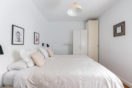 1 dormitorio blanco con 1 cama blanca grande en Azahar, en Sevilla