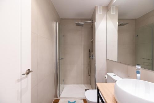 een badkamer met een douche, een wastafel en een toilet bij Azahar in Sevilla