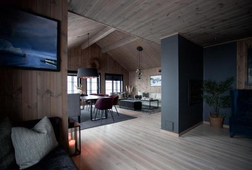 un soggiorno con TV e una sala da pranzo di Strandafjellet Panorama Lodge - Large Cabin with Majestic Mountain View a Stranda