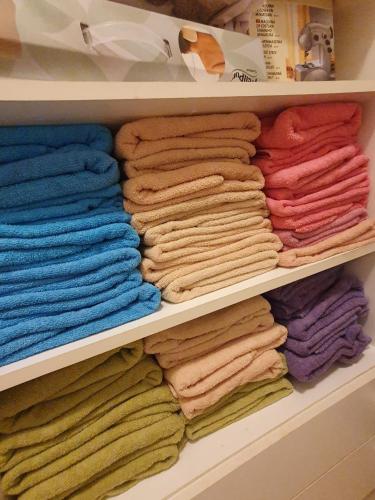 un placard rempli de nombreuses serviettes de toilette de couleur différente. dans l'établissement HOSTEL BBC, à Prague