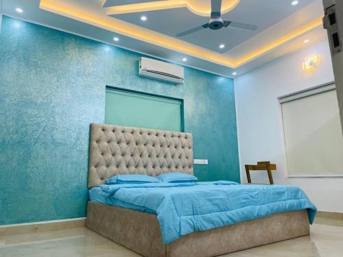 a bedroom with a bed with a blue wall at Second home International airport T-1 in Trivandrum