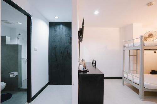 a bathroom with a black door and a bunk bed at Noble House Patong in Patong Beach