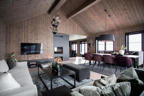 斯特蘭達的住宿－Strandafjellet Panorama Lodge - Large Cabin with Majestic Mountain View，客厅配有沙发和桌子