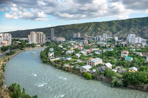 a city next to a river with buildings at Royal Tulip Hotel & Casino, Tbilisi in Tbilisi City