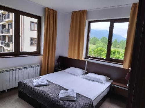 a bedroom with a bed and two windows at M&R Apartment C13 - SPA Terra Complex in Razlog