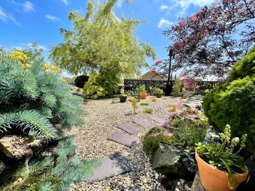 a garden with rocks and plants and trees at Bojangles Guest House in Gretna Green