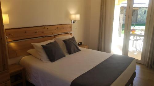 1 dormitorio con 1 cama blanca grande con almohadas en Lou Pic au Loup - Gîte Loup en Cazevieille
