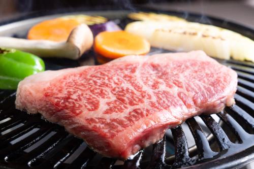 a piece of meat and vegetables on a grill at Hanare no Yado Hanagokoro in Minamioguni
