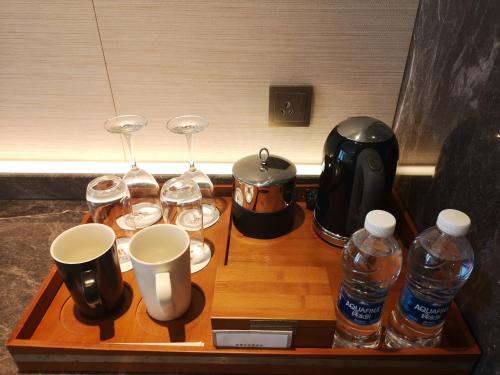 a wooden tray with wine glasses and water bottles at Marriott Resort Xiangshui Bay in Lingshui