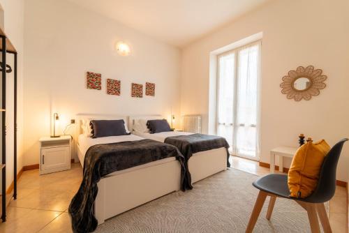 a bedroom with two beds and a window at Bright and Cozy in Menaggio by Wonderful Italy in Menaggio