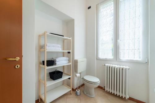 a bathroom with a toilet and a window and a radiator at Bright and Cozy in Menaggio by Wonderful Italy in Menaggio