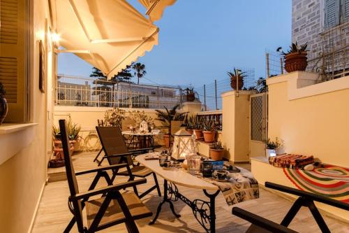 a patio with a table and chairs on a balcony at YANMAR PLACE in Ermoupoli