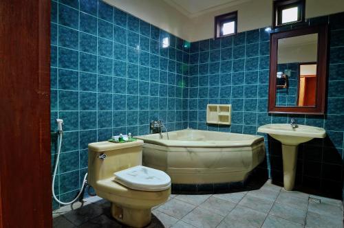y baño con aseo, bañera y lavamanos. en Dewi Sinta Hotel and Restaurant, en Tanah Lot