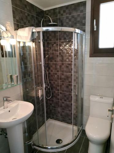 a bathroom with a shower and a toilet and a sink at Vigla Village in Spartià