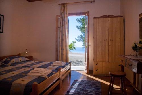a bedroom with a bed and a door to a beach at Vigla Village in Spartià