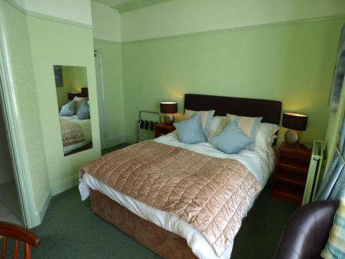 a bedroom with a large bed and a mirror at The Southcliff in Tenby