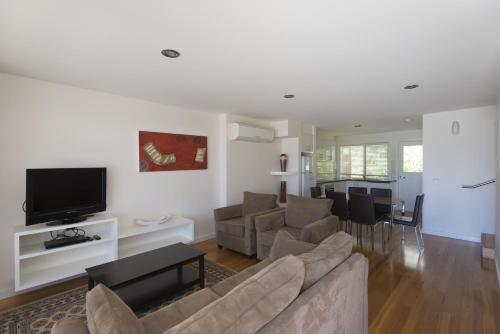 a living room with a couch and a tv at Port Campbell Parkview Motel & Apartments in Port Campbell