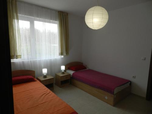 um quarto com 2 camas, uma janela e um candeeiro em Villa Campo em Ezerets