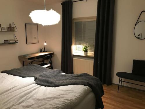 1 dormitorio con cama, escritorio y ventana en Fräsch centrumlägenhet!, en Mariehamn
