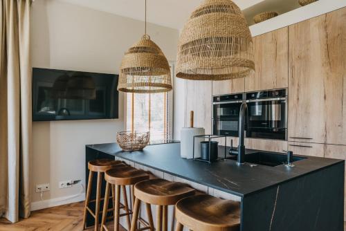 a kitchen with a black counter and stools at Nautica Resort in Giżycko
