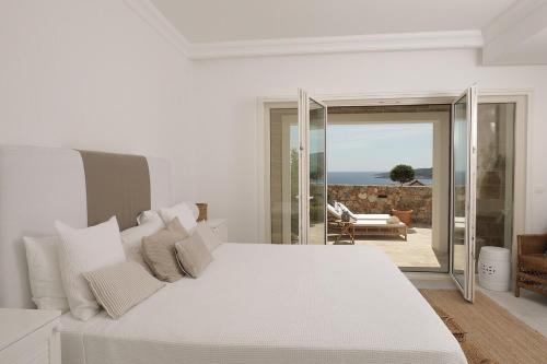 - une chambre blanche avec un lit blanc et un balcon dans l'établissement Apartment Vista By 2bhome, à Radovići
