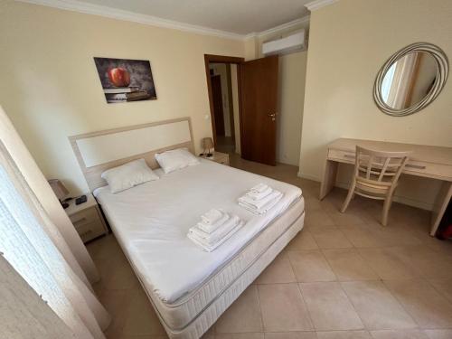 1 dormitorio con cama, mesa y espejo en Quiet apartment with big terrace in Santa Marina with parking, en Sozopol