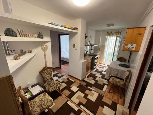 sala de estar con mesa y sillas y cocina en Bubu Apartament, en Petroşani