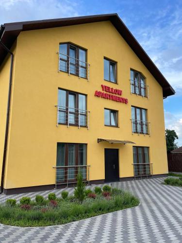 a yellow building with a sign that readsweekly advancements at Yellow apartments in Boryspilʼ